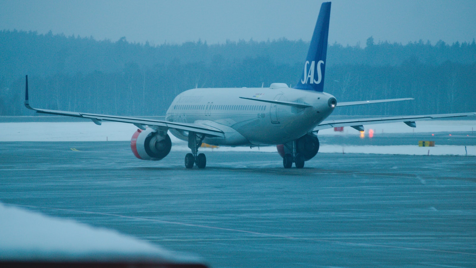 An sas airplane on a snowy airport runway in winter