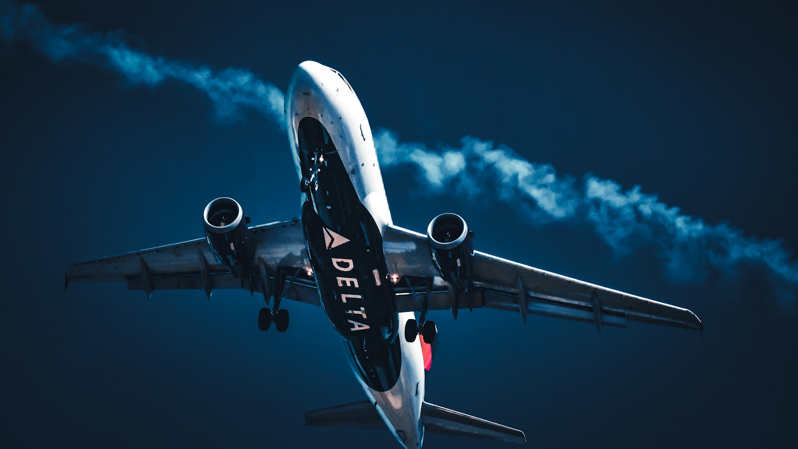 Airplane connected to a jet bridge at sunset