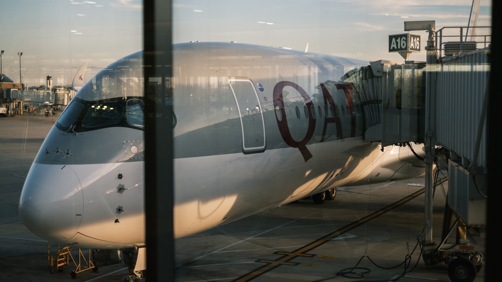 a large Qatar Airways passenger jet at the gate