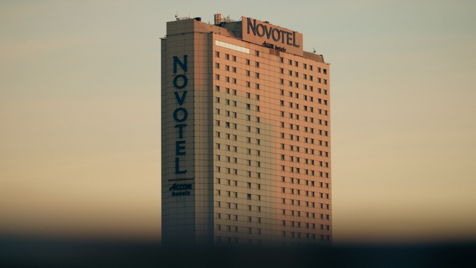 Tall novotel hotel building against a pale sky