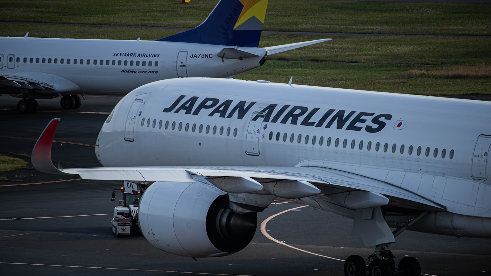 two japan airlines planes parked on the tarmac